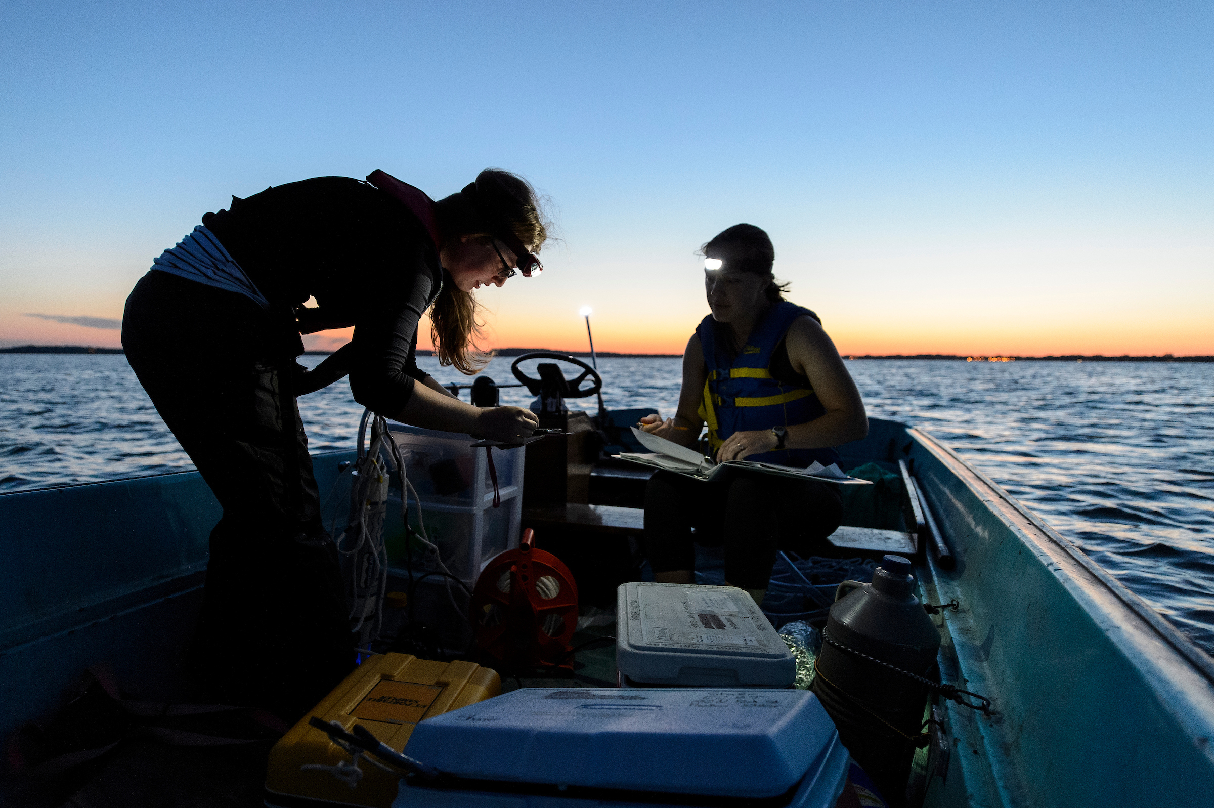 students working on a research boat at dawn