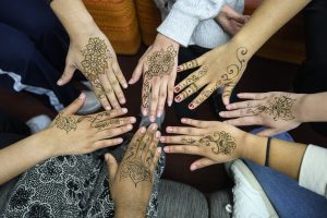 a circle of henna-decorated hands 