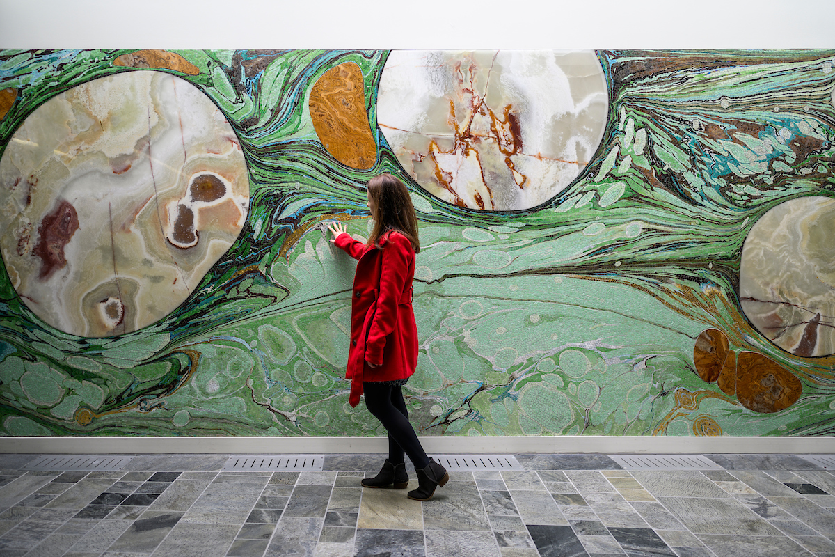 a woman stands in front of wall art